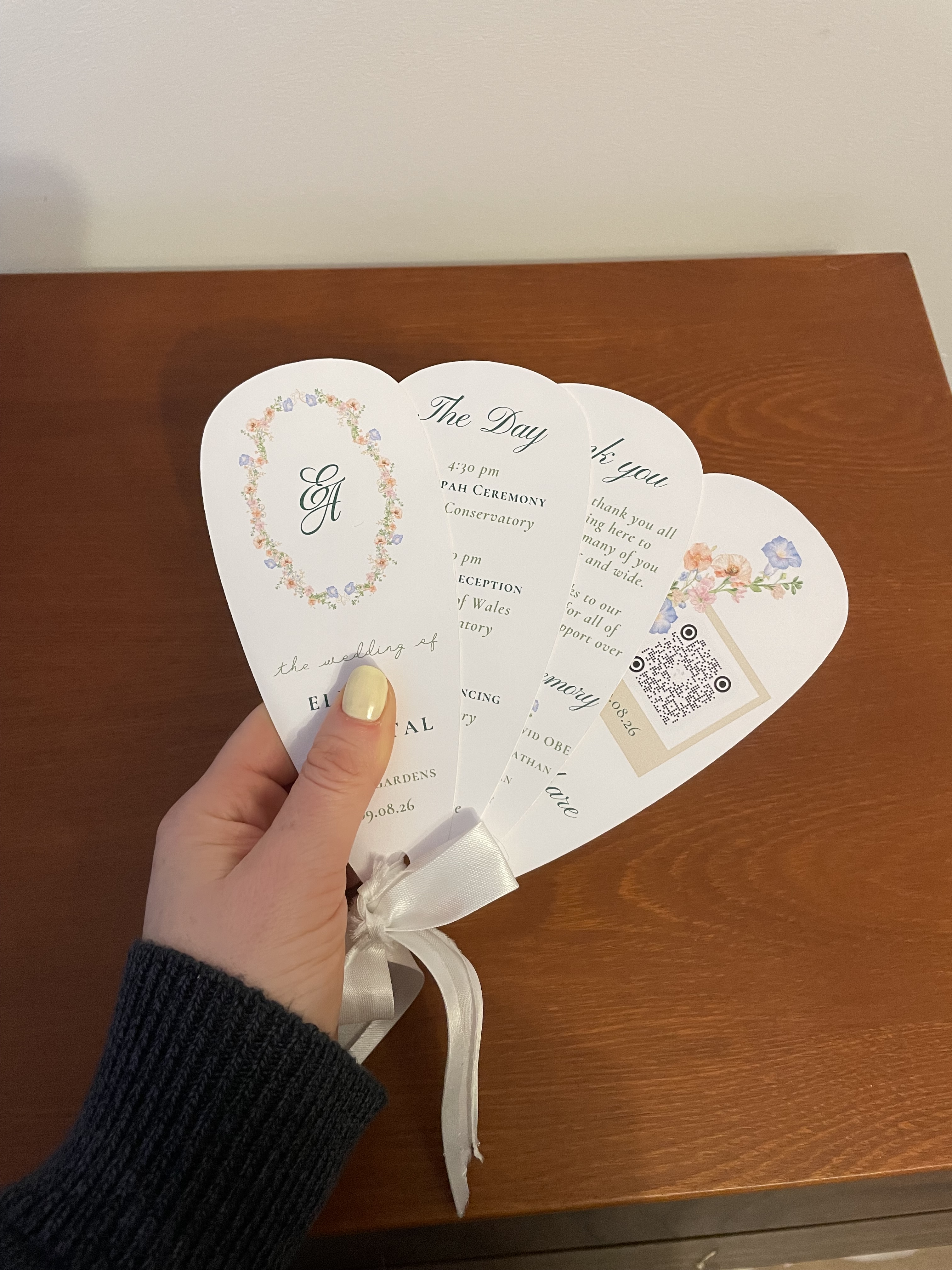 Håndlagde bryllupsvifter og programmer laget med hjelp fra en leid Cricut-maskin.